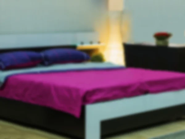 Blurred bedroom with purple and violet bed