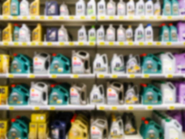 Blurred motor oil on shelves in supermarket