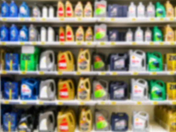 Blurred motor oil on shelves in supermarket