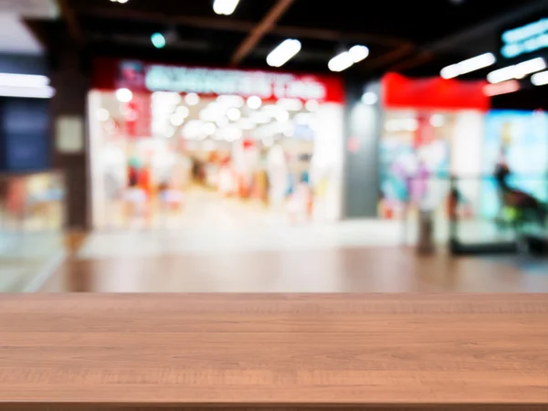 Wooden empty table in front of blurred mall