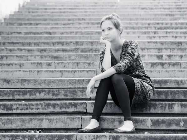 Sad girl sitting on steps