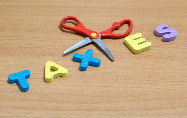Scissors and the plastic alphabet TAXES.