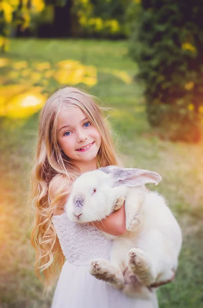 Girl playing with a huge rabbit