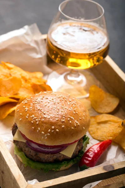 Hamburger with meat cutlet. Potato chips and beer