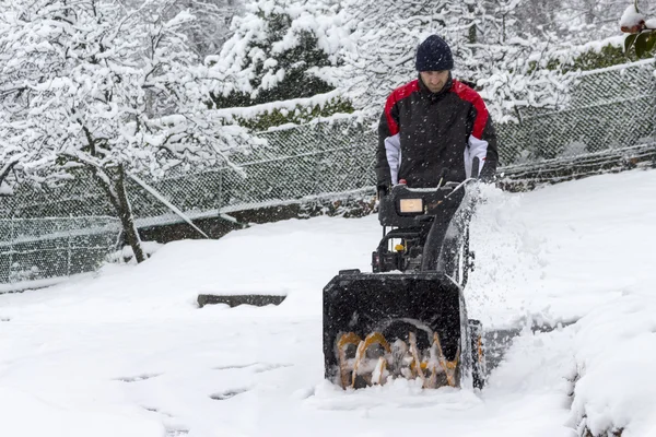 Man removing snow with a snow blower