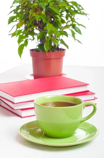 Cup of tea, books stack and indoor plant. Concept of reading, st