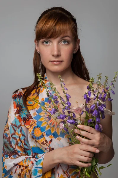 Beautiful woman holding flowers. Female model studio portrait. R