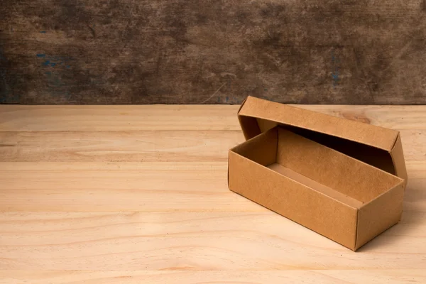 Opened cardboard box on wooden background