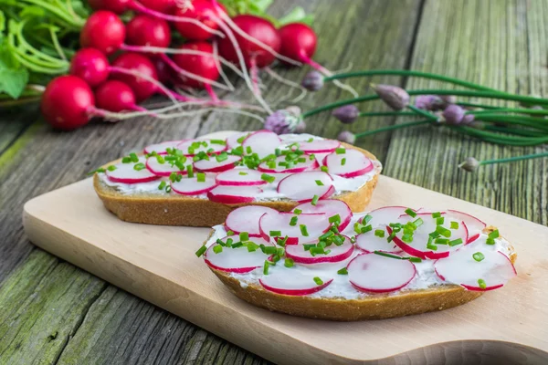 Bread with Curd Cheese, Radishes and Chive on Wooden Board on ol