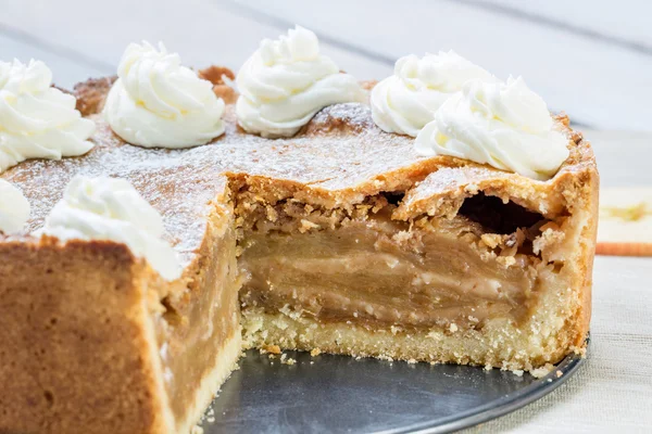 Detail on a Sliced Apple Pie with Whipped Cream with Cinnamon an