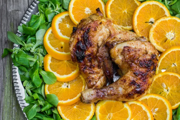 Top View on a Grilled Chicken with Oranges and Salad on a Silver