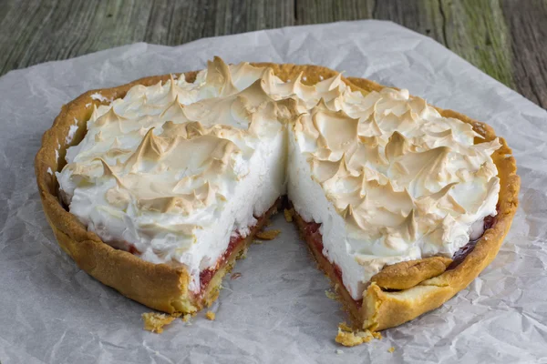 Sliced Meringue cake with strawberry jam on baking paper