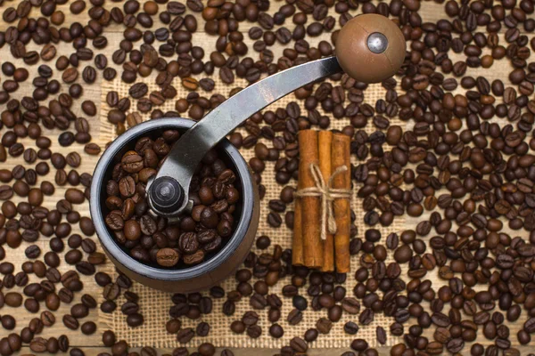 Coffee mill full coffee beans with cinnamon sticks