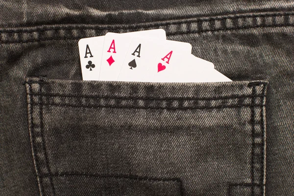 Four ace cards inside gray jeans back pocket
