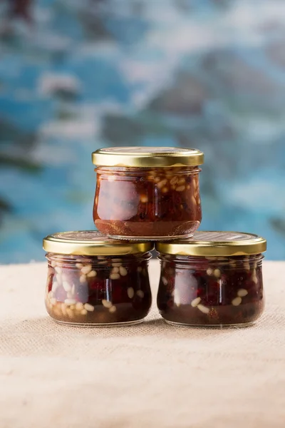 Three jam jars with berries and pine nuts