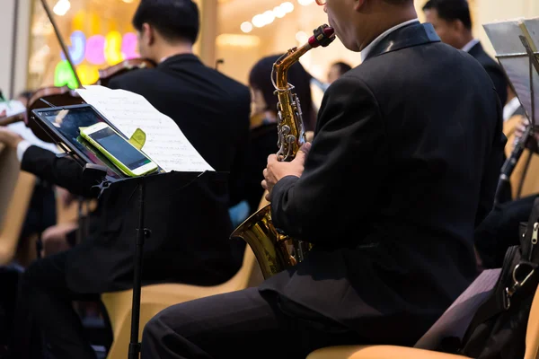 People show the saxophone in singing party.