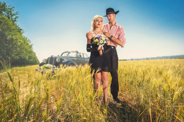Wedding couple on wheat field near car