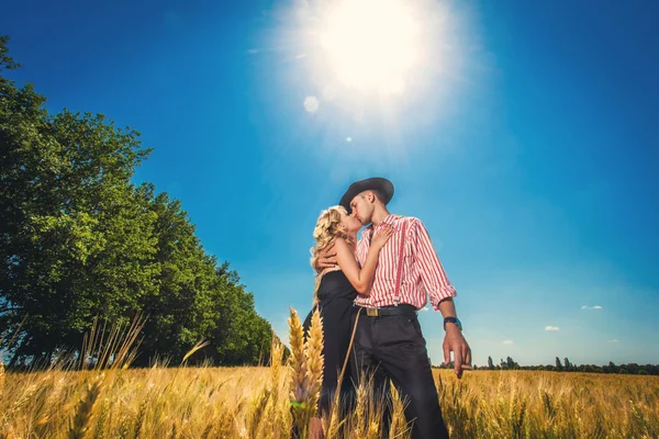 Kissing man and woman on a wheat field