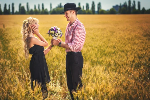 Couple with elegant bouquet on field