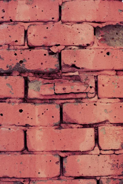Wall of red broken bricks
