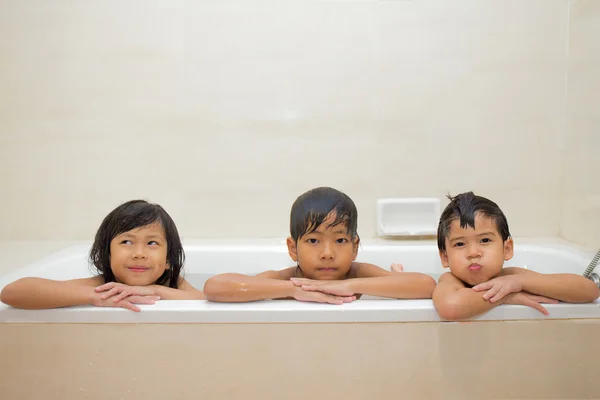 3  Asian children play and take a bath  in bathtub
