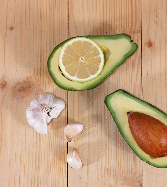 Portion of avocado, clove garlic and lemon, concept of healthy food