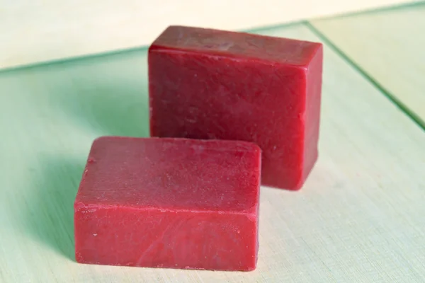 Soap bar flavor with rose ingredient isolated on wooden board ba
