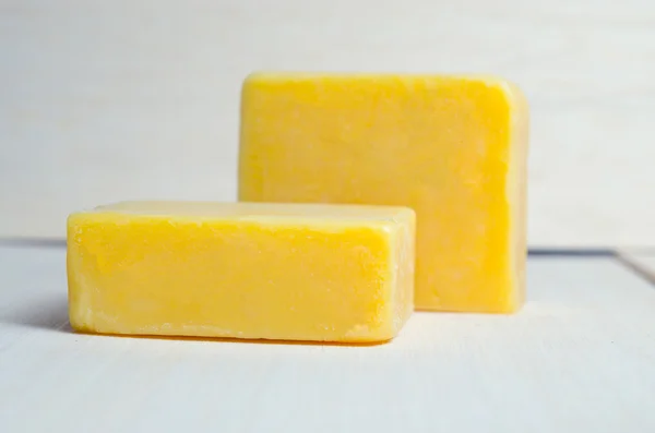 Soap bar flavor with mango ingredient isolated on wooden board b