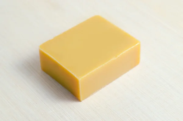Soap bar flavor with mango ingredient isolated on wooden board b