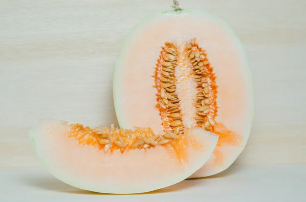 Cantaloupe or Charentais melon with half and seeds on wooden boa