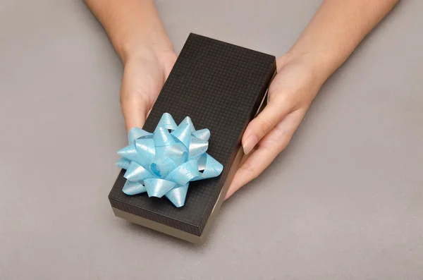 Offer of gift box present with hand holding it, Christmas and ne