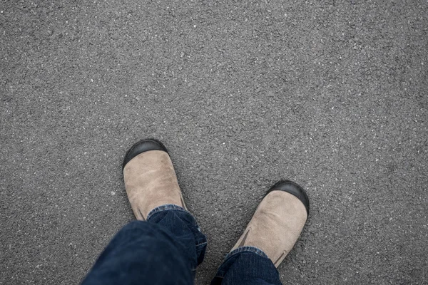 Brown shoes standing on the asphalt concrete floor