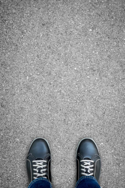 Black casual shoes standing on the road