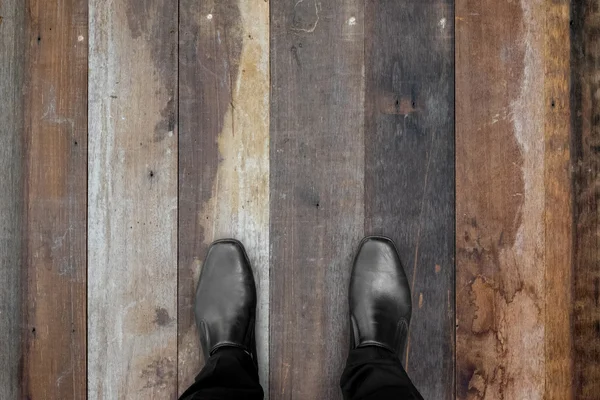 Black shoes standing on wooden floor