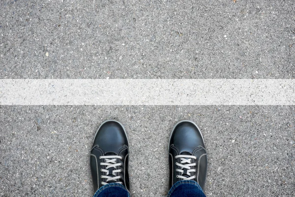 Black casual shoes standing at the white line