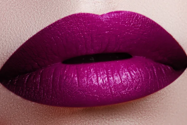 Close-up shot of woman lips with glossy fuchsia lipstick. Perfect fuchsia lips. Sexy girl mouth close up. Beauty young woman smile. Fuchsia plump full Lips. Lips augmentation. Close up detail. Bright full lips