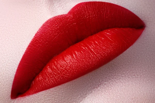 Close-up of woman\'s lips with fashion red make-up. Beautiful female mouth, full lips with perfect makeup. Classic visage. Part of female face. Macro shot of beautiful make up on full lips