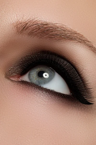 Macro shot of woman\'s beautiful eye with extremely long eyelashes. Sexy view, sensual look. Female eye with long eyelashes