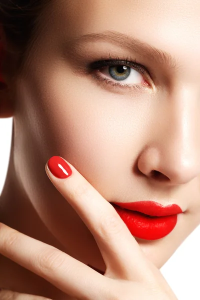 Beautiful woman young model with red lips and red manicure. Beautiful young girl with a bright make-up and red nails