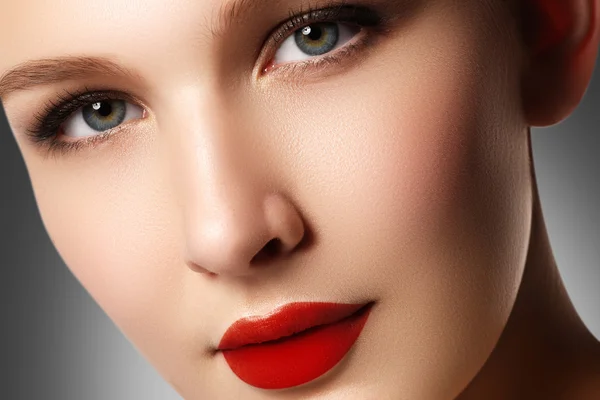 Wellness, cosmetics and chic retro style. Close-up portrait of sensuality beautiful woman model face with fashion make-up and sexy evening red lips makeup. High fashion look