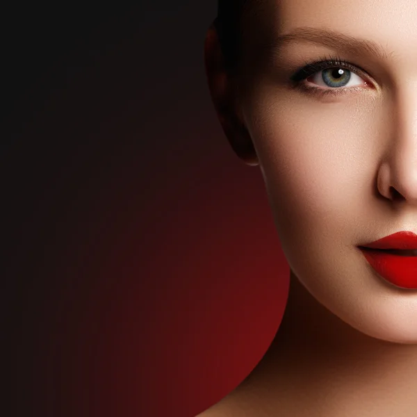 Wellness, cosmetics and chic retro style. Close-up portrait of sensuality beautiful woman model face with fashion make-up and sexy evening red lips makeup. High fashion look