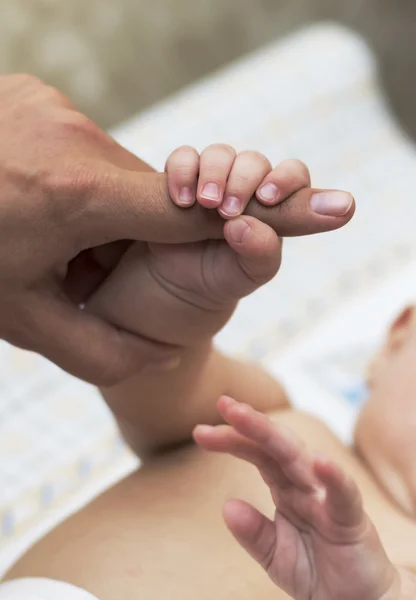 Child's hand holding mother's finger