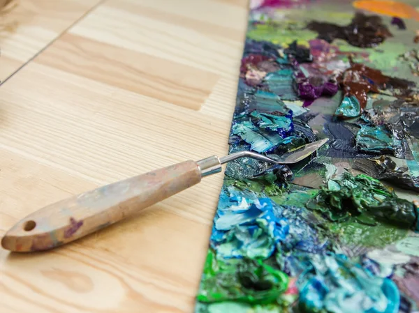 Artist brushes, palette knife and palette with paints impression