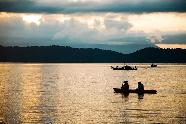 People in canoe floating in sea