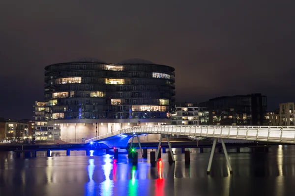 Modern cyclist bridge and Gemini Residence in Copenhagen by night
