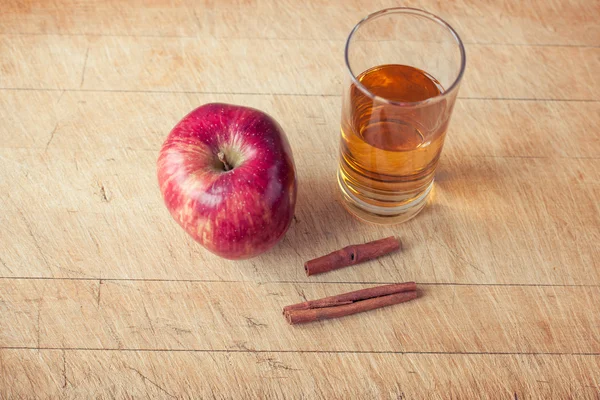 Apple and a glass of apple juice on a wooden board