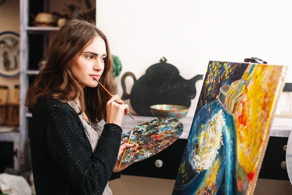 Creative pensive painter paints a colorful picture