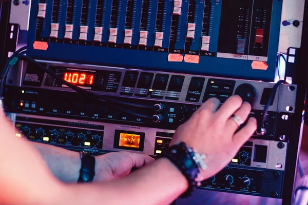 Musician adjusts sound panel  in recording studio