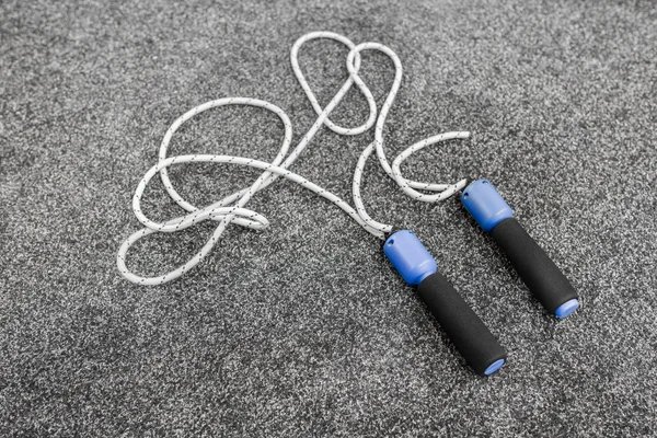 Skipping rope on grey background top view