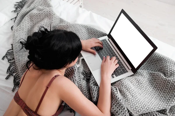 Nude woman typing on laptop with white screen
